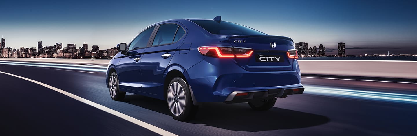 Honda City in blue, rear view at dusk